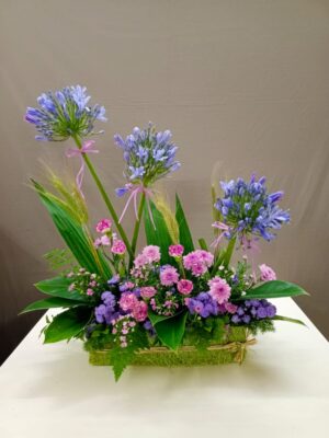 Elegant side basket flower arrangement with agapanthus