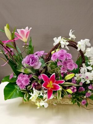 Pink lilium basket arrangement with white orchids