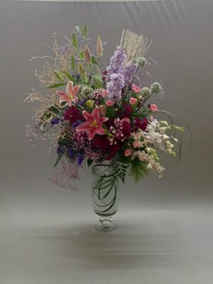 Premium pink standing flower arrangement with lilies, orchids, and carnations in clear glass vase