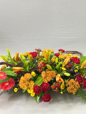 Luxury mixed flower table arrangement with orange lilies, red anthuriums, chrysanthemums and carnations