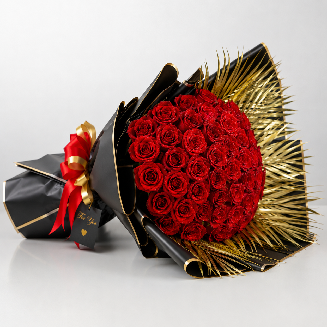 Luxury bouquet of 75 fresh red roses with black wrapping and golden palm leaves