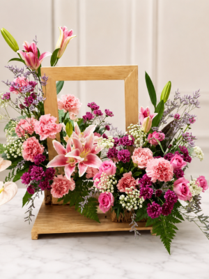 Elegant wooden frame floral arrangement with pink lilies, carnations, roses, baby’s breath, and fresh greenery in a modern decorative design