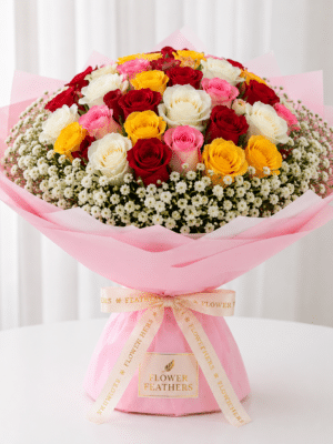 Luxury mixed bouquet of red, white, pink, and yellow roses with baby's breath wrapped in premium pink paper by FlowerFeathers Mumbai.
