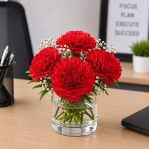 Office desk flower arrangement with carnation in a glass vase