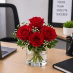 Office desk flower arrangement with Red roses in glass vase