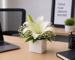 Office desk flower arrangement with white lilie in a ceramic vase