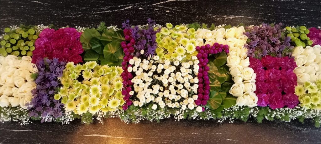 Premium floral runner arrangement with white roses, pink hydrangeas, green chrysanthemums, purple fillers, berries, and baby’s breath for elegant table decoration.